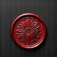 Stylized Numismatika Zolotaya seal logo in the site footer